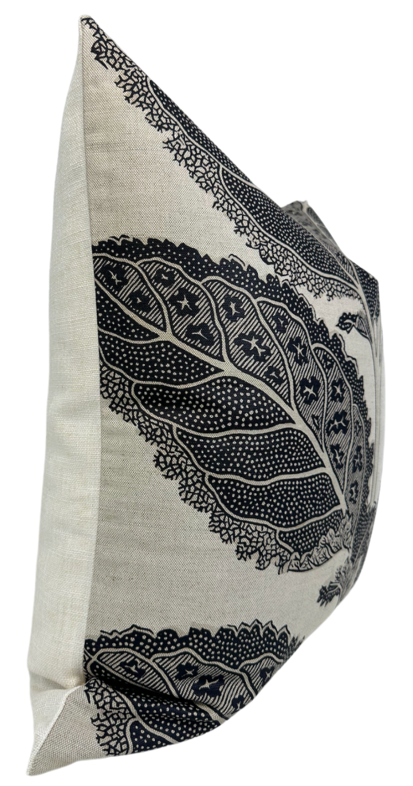 Side view of a square pillow with beige fabric and black intricate lace-like leaf patterns forming a bold, detailed border design.