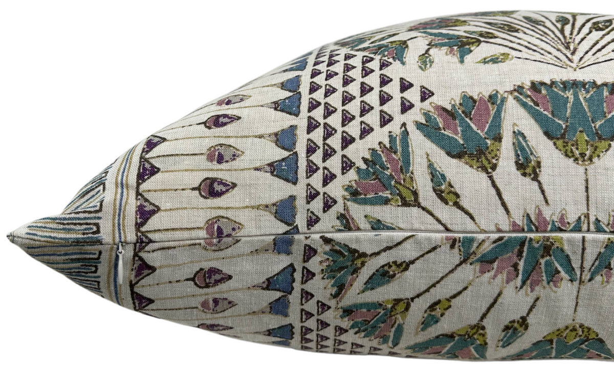 Side view of a rectangular pillow with a muted beige background featuring intricate patterns in eggplant purple, teal blue, and olive green.