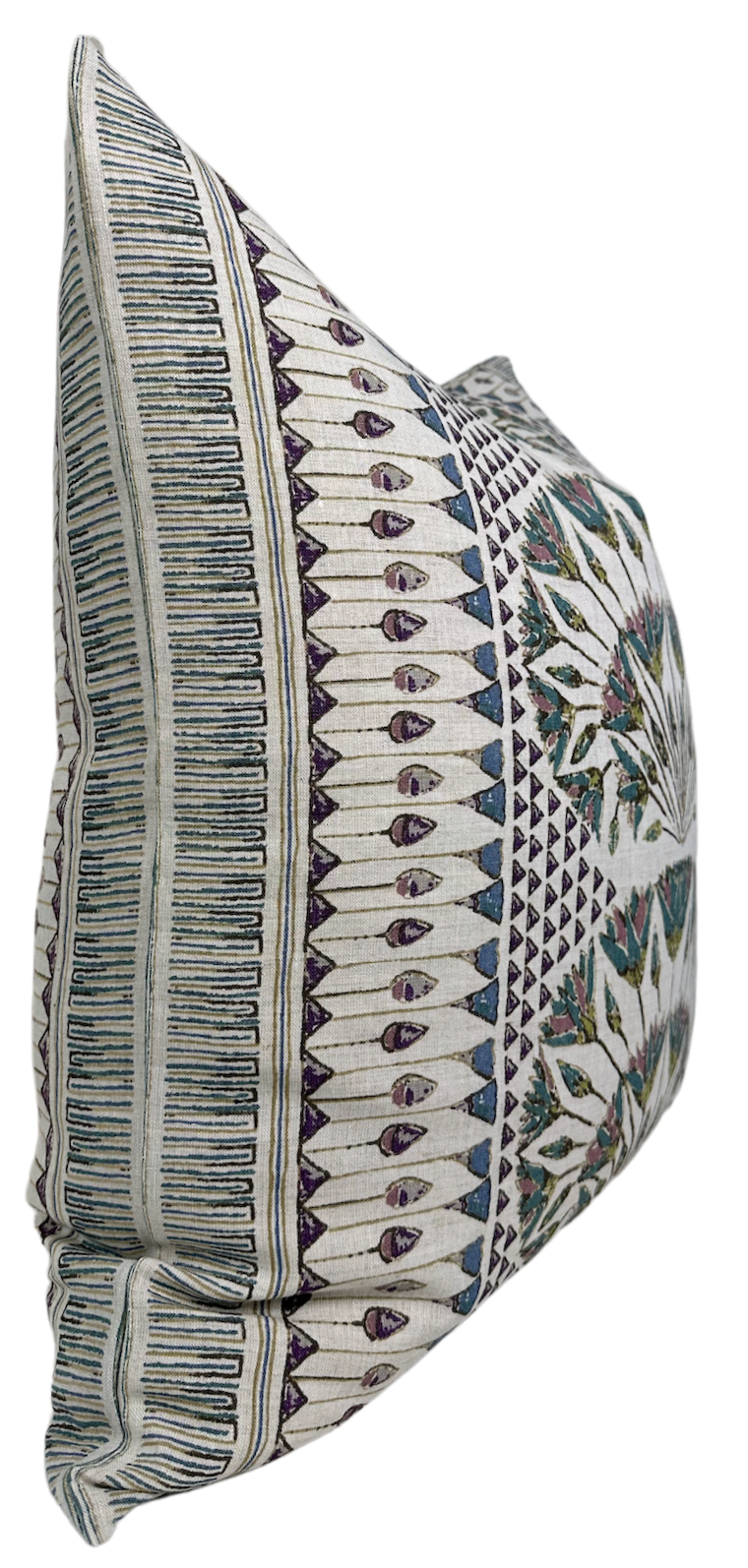 Square pillow with symmetrical, multicolored geometric pattern featuring teal, purple, and green shapes on a light gray background, shown from side angle.