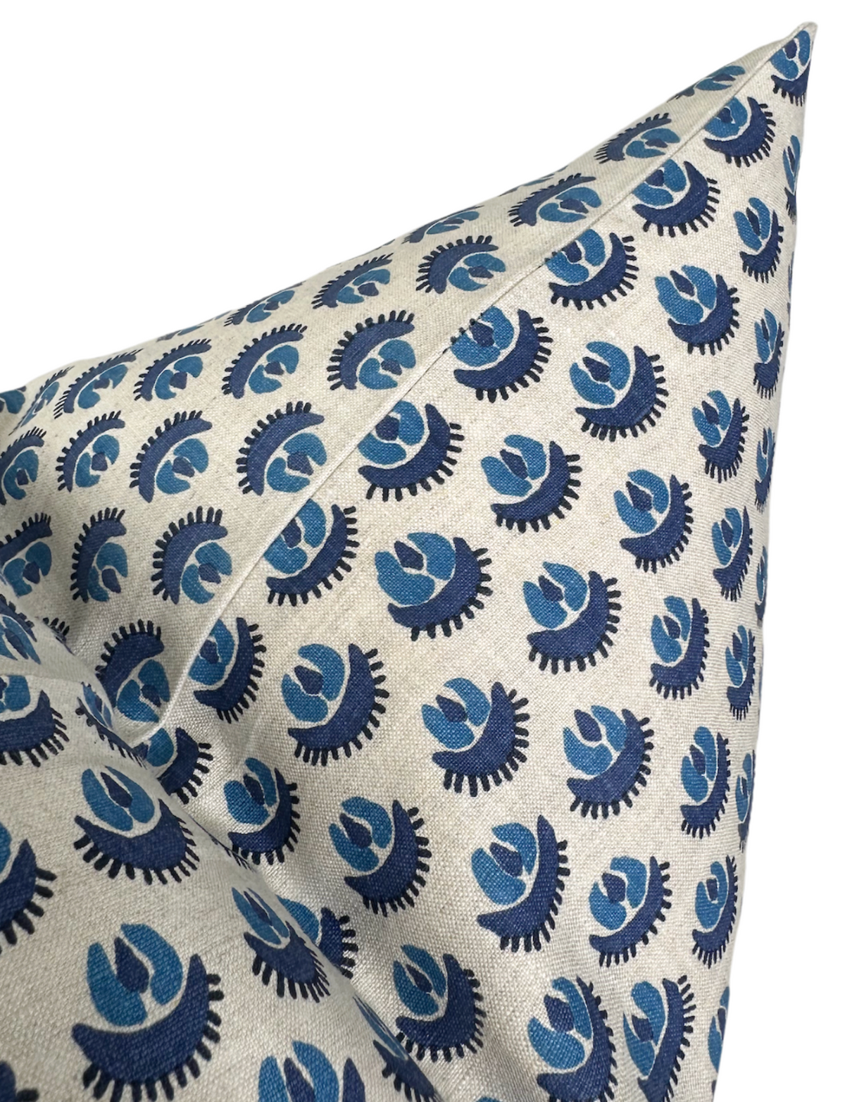 Close-up of a beige pillow cover with a repetitive pattern of stylized blue and navy floral motifs arranged evenly across the fabric.