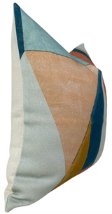 Pillow cover with abstract geometric design in apricot, teal, mustard, and blue shapes on a textured fabric background.