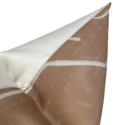 Close-up of a pillow corner featuring salmon-colored fabric with white abstract line patterns, contrasted with a plain cream-colored back fabric.
