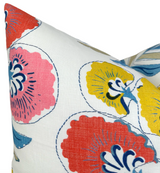 Close-up of a pillow with coral and yellow stylized floral patterns outlined in navy blue on white fabric, highlighting vibrant, large flower shapes and delicate leaf details.