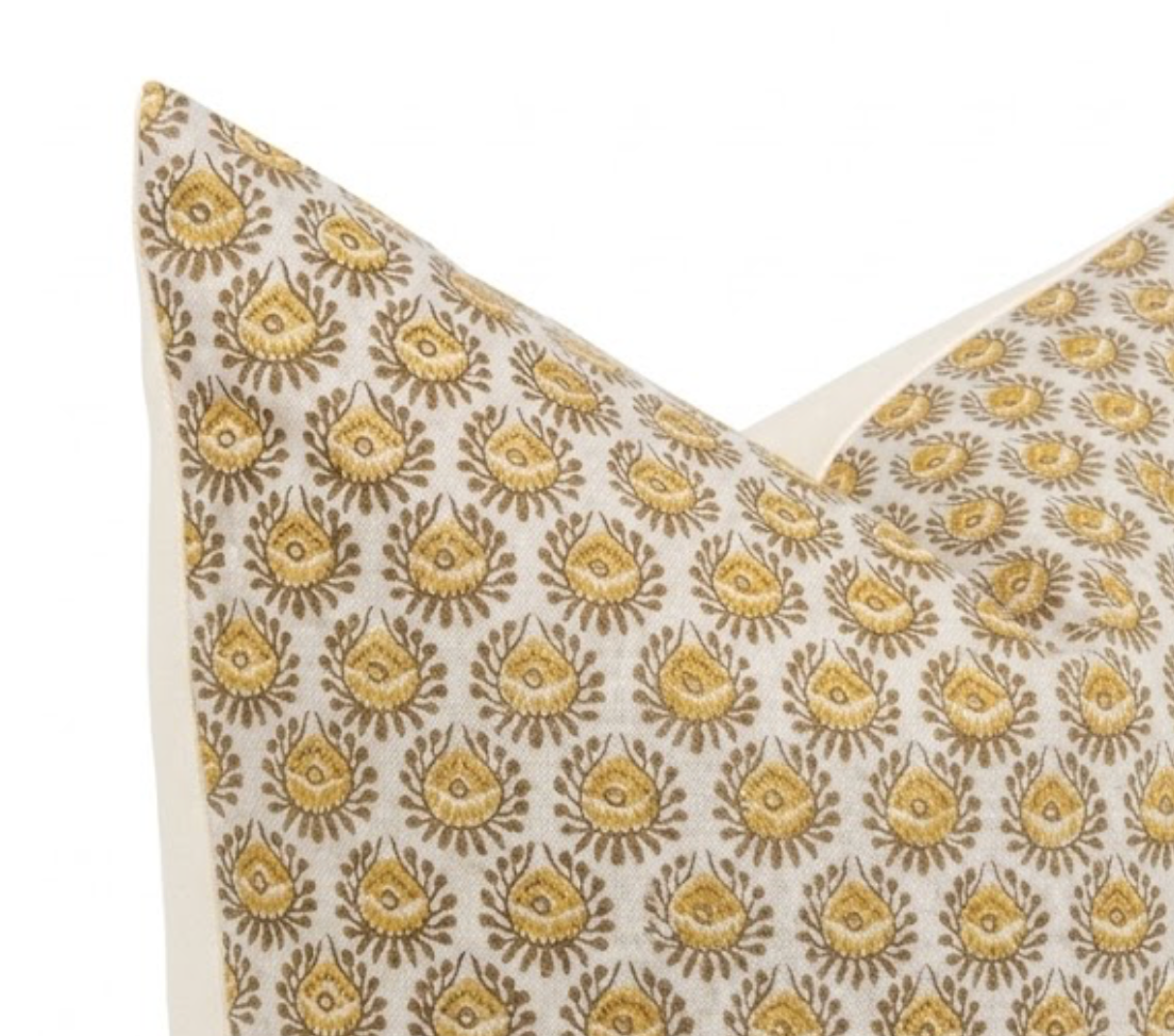 Square pillow with a cream background and repeating saffron yellow floral pattern, shown from a close-up front angle highlighting the design detail.