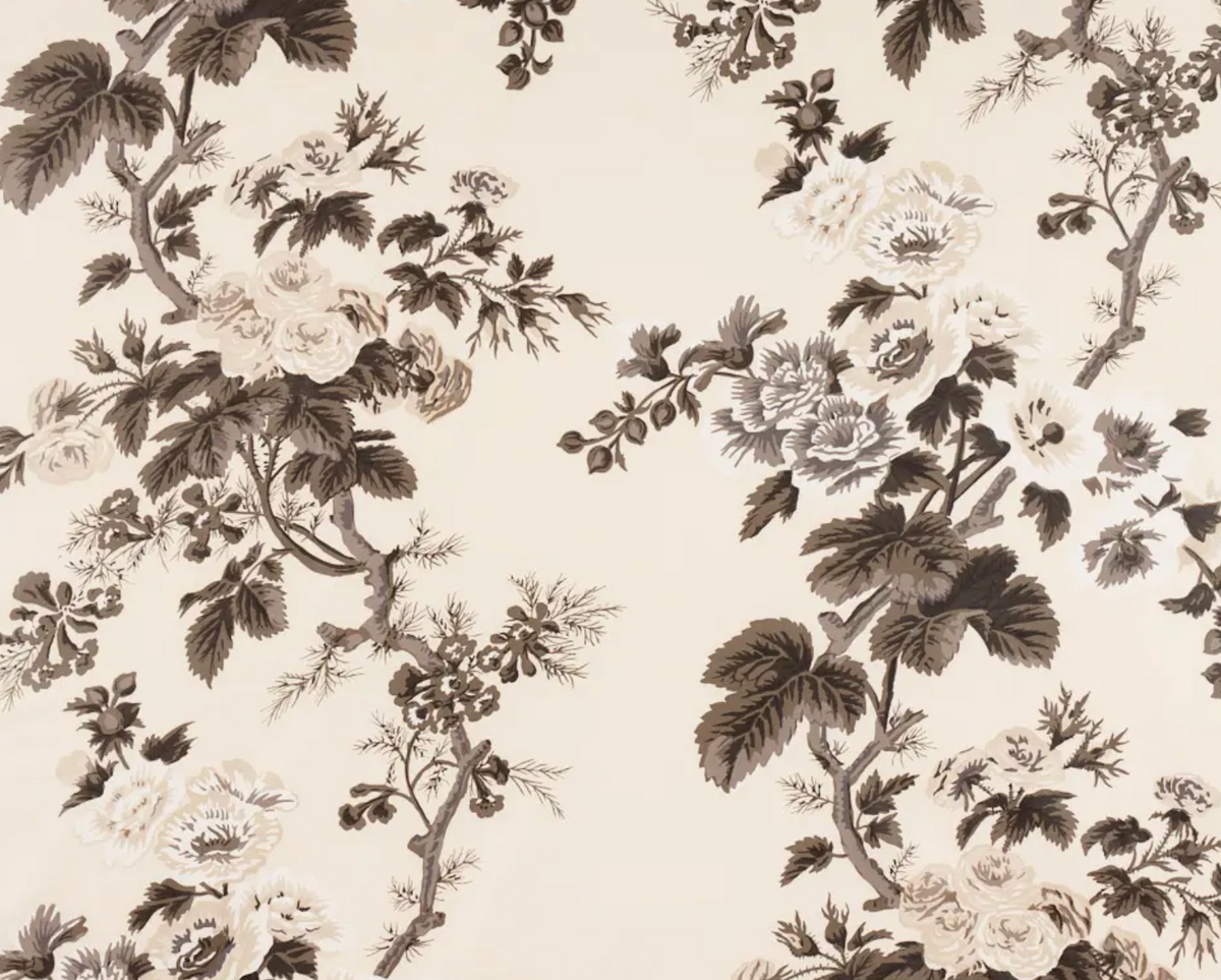 Floral fabric with charcoal-colored hollyhock flowers and leaves on a cream background, featuring detailed botanical patterns in grayscale tones.