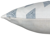 Close-up of a white pillow cover with blue triangular patterns featuring intricate floral designs and a visible zipper on the side seam.