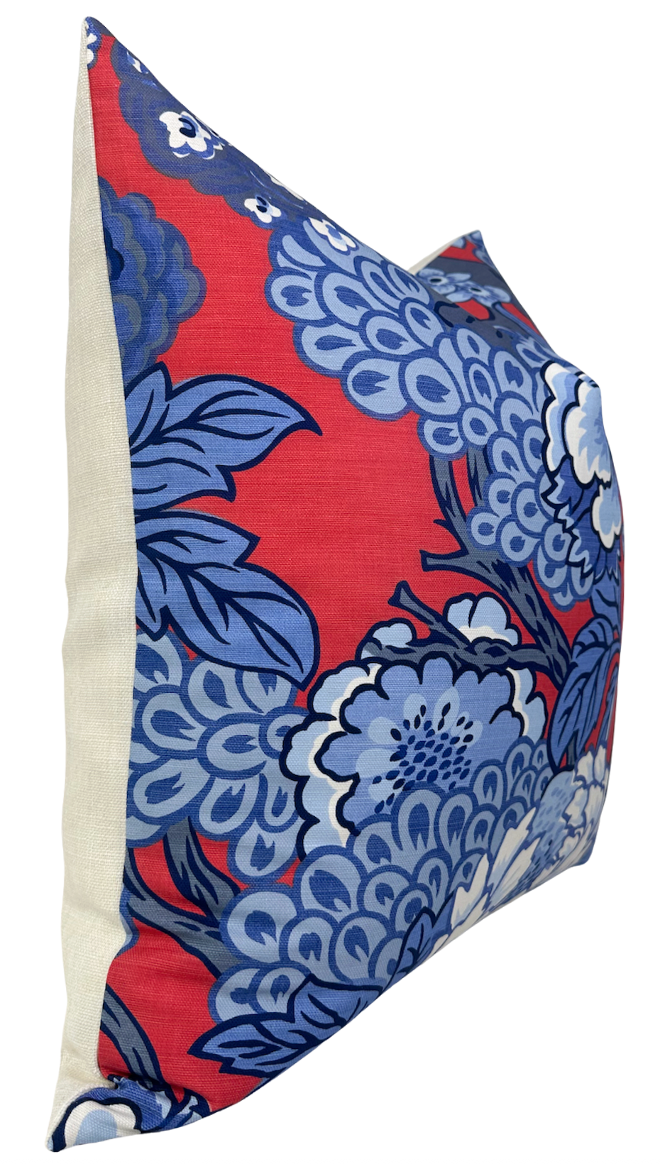 Square pillow cover with bright red front featuring large blue floral patterns and cream-colored back panel, shown at an angled side view.