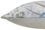 Close-up of a pillow corner with a pale blue background featuring a floral and branch pattern in muted green, blue, and beige tones.