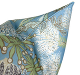 Close-up of a Spa Blue pillow corner featuring a floral Protea pattern with green leaves and white, spiky blossom details on a blue fabric background.