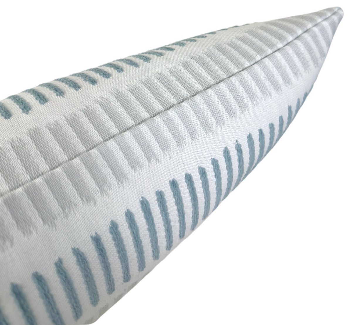 Close-up of a pillow corner featuring a light grey fabric with a textured, repeating pattern of vertical slate blue dashes and subtle raised stitching detail.