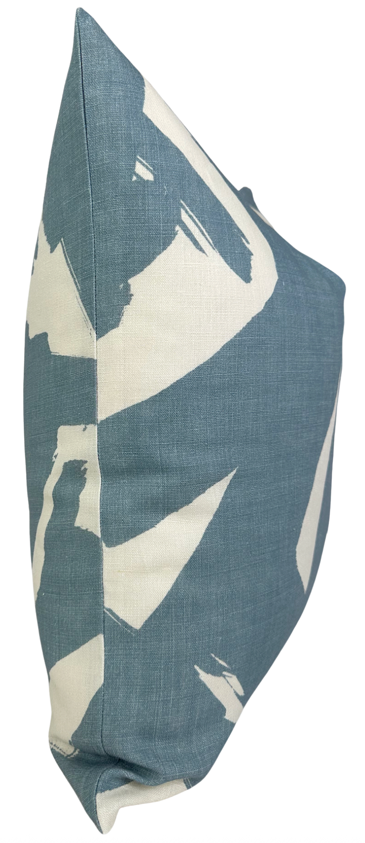 Square linen pillow cover with a bold abstract pattern in muted sky blue and off-white, shown from a side angle highlighting its corner and texture.