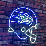 Neon sign shaped like a Seattle Seahawks football helmet with distinct blue outline, green eye detail, and white facemask illuminating against a brick wall.