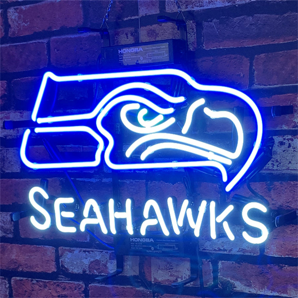 Blue neon light sign of a fierce hawk head above the word Seahawks in white neon, mounted on a dark red brick wall.