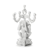 White sculptural candelabra featuring three monkeys covering eyes, ears, and mouth, blending classic baroque arms with playful figurative design.