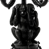 Black sculpture of three monkeys in classic 'see no evil, hear no evil, speak no evil' poses, intricately detailed with textured fur and seated closely together.