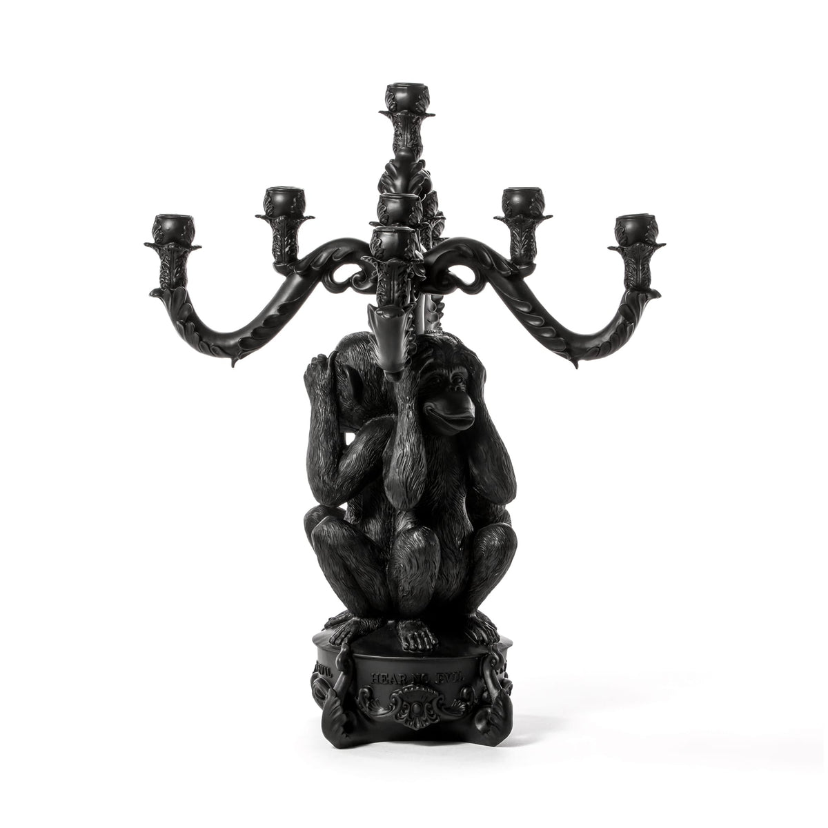 Black sculpted candelabra featuring three monkeys covering their eyes, ears, and mouth, holding five curved candle holders above them.