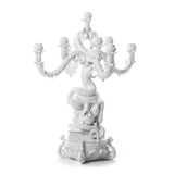 White sculptural candelabra featuring a coiled snake entwined around a human skull with five ornate candle holders extending outward.