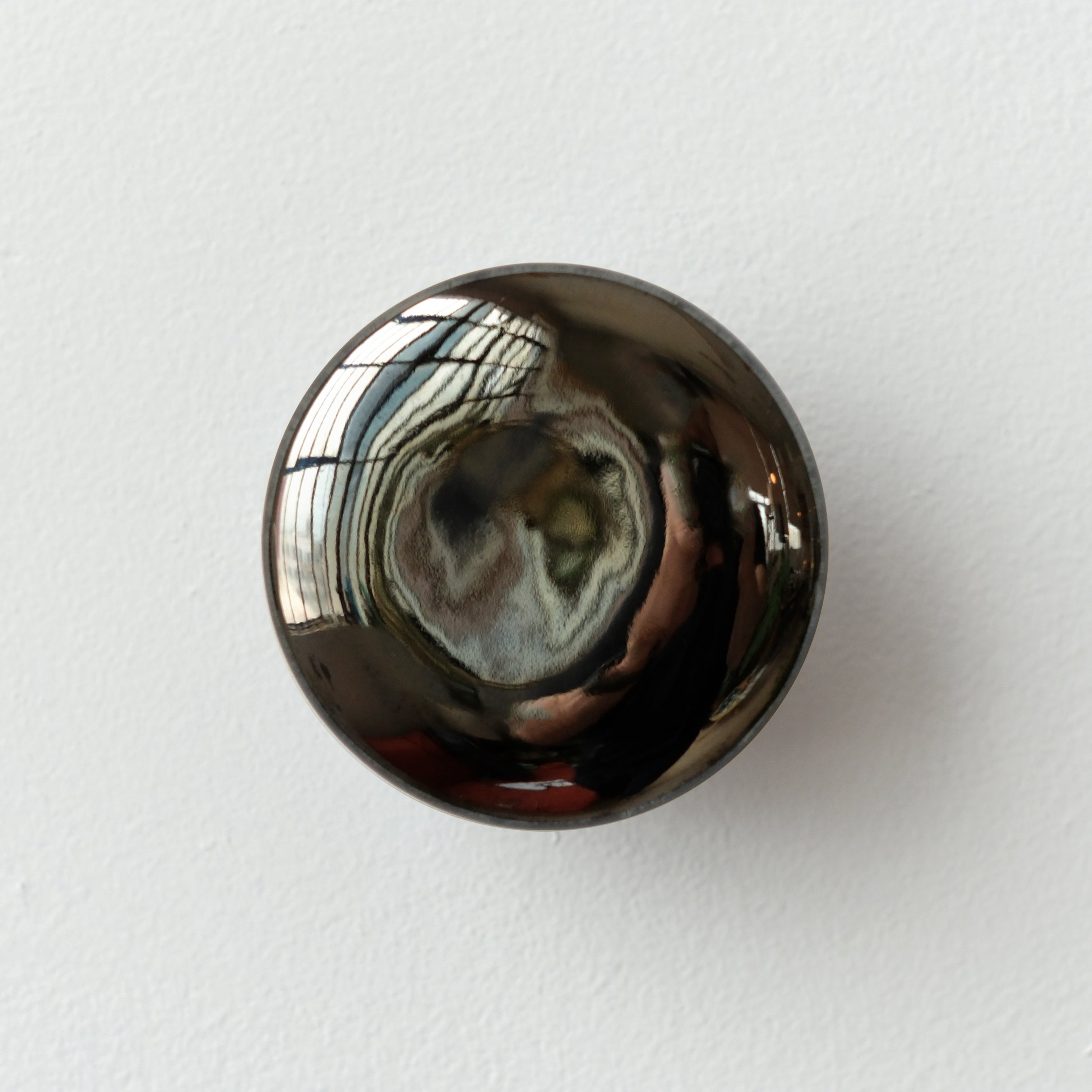 Sequence coat hook in Mercury dark chrome finish mounted on wall
