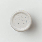 Sequence coat hook - Revolve in speckle color, showing curved ceramic form on white wall