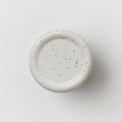 Sequence coat hook - Revolve in speckle color, showing curved ceramic form on white wall