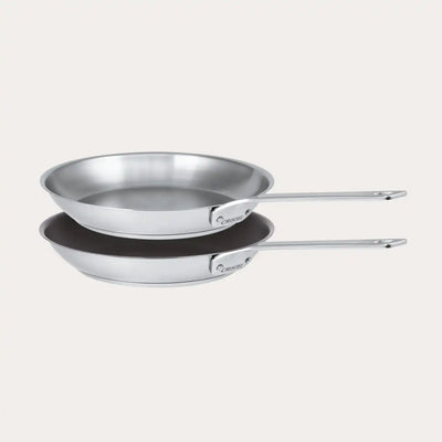 Set of two frying pans from CRISTEL USA's 1826 collection displayed on a black surface