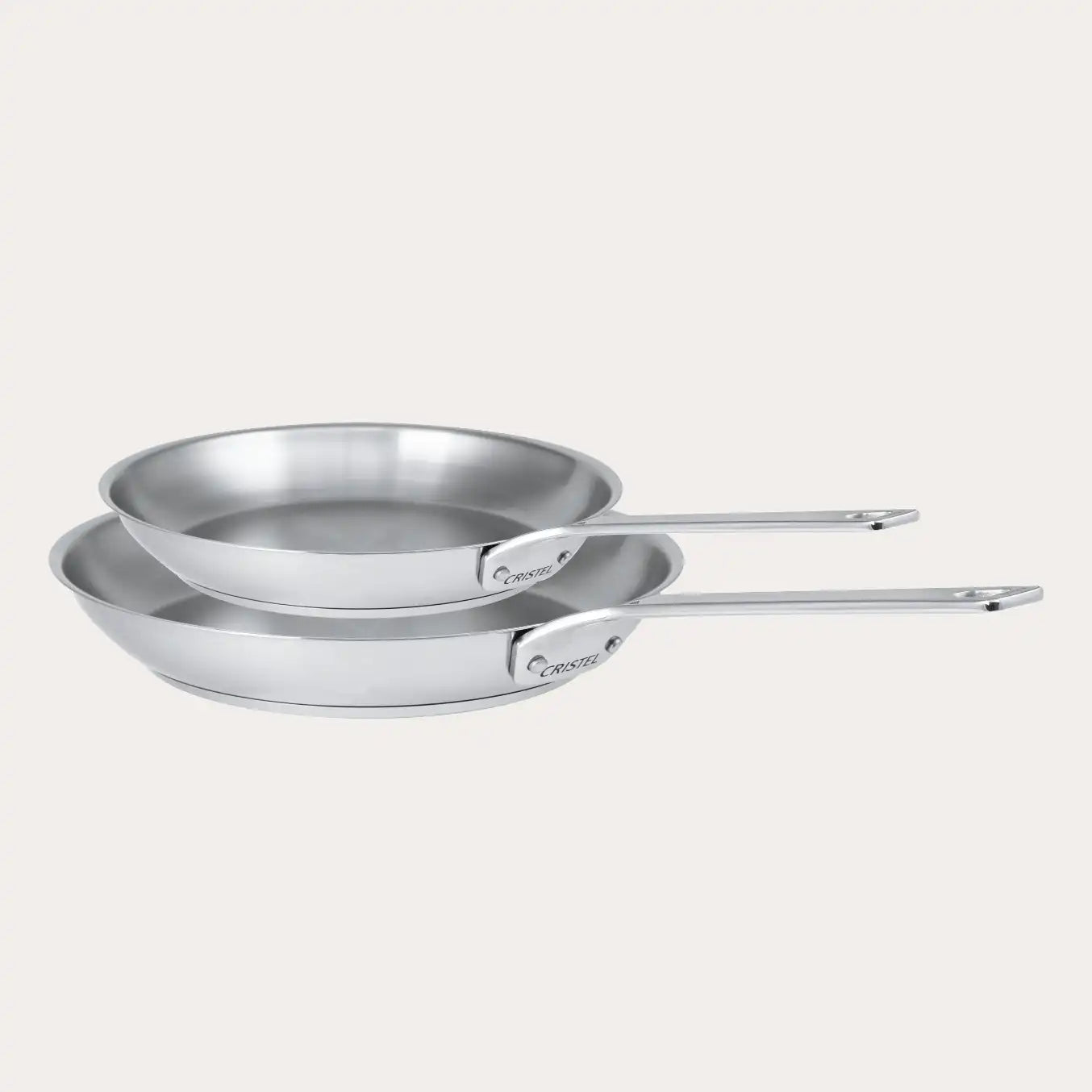 Two stainless steel frying pans from CRISTEL USA's 1826® collection displayed on a neutral background