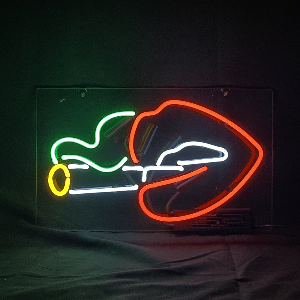 Red neon lips holding a white cigarette with a yellow tip and green smoke against a dark background.