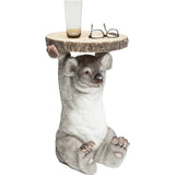 Side table with a detailed koala figure holding a round wood-slice tabletop, featuring realistic gray fur texture and small ears, holding a glass and glasses on top