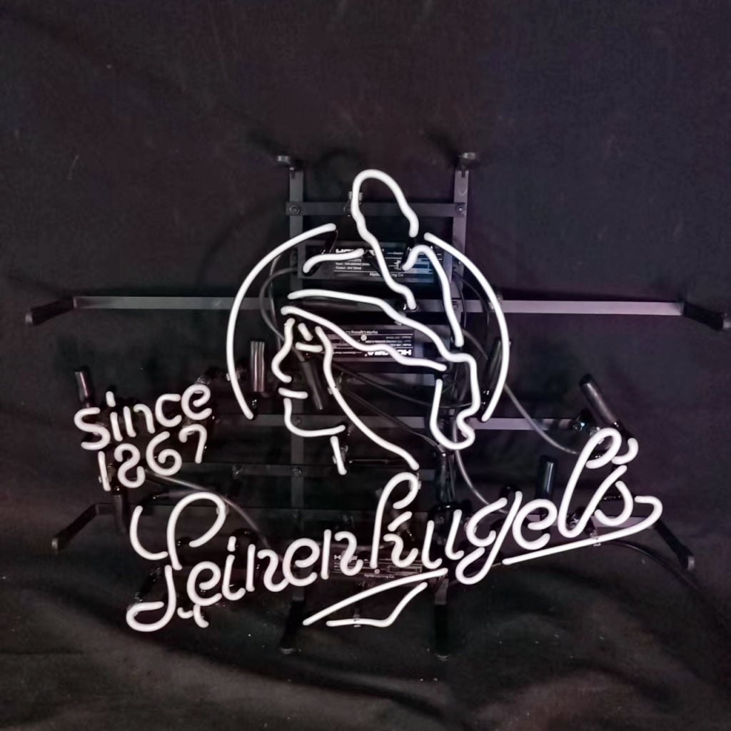 White neon sign depicting a profile of a woman wearing a feathered hat, with cursive text 'Leinenkugel's' and 'since 1867' on a black background.
