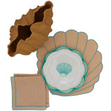 Brown ceramic vase with irregular wavy rim next to a seashell-shaped placemat, a matching napkin with blue edging, and a white plate featuring a blue seashell design.