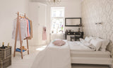 Handcrafted wooden garment rack holding clothes and coats in a home setting