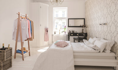 Handcrafted wooden garment rack holding clothes and coats in a home setting