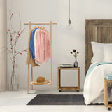 Handcrafted wooden garment rack holding clothes and coats in a home setting