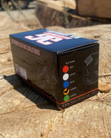 Black box for RL15 LED rock light showing available colors red, white, blue, amber, and green with product logo and background outdoors on rough wood surface.
