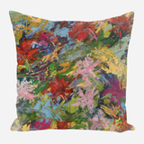 Square pillow with an abstract floral pattern in bold brushstrokes featuring reds, greens, pinks, blues, and yellows on a light background.