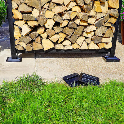 Black and brown firewood rack support bases stacked on concrete and grass surfaces