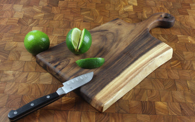 Small live edge cutting board made of East Indian Walnut with a natural shaped handle