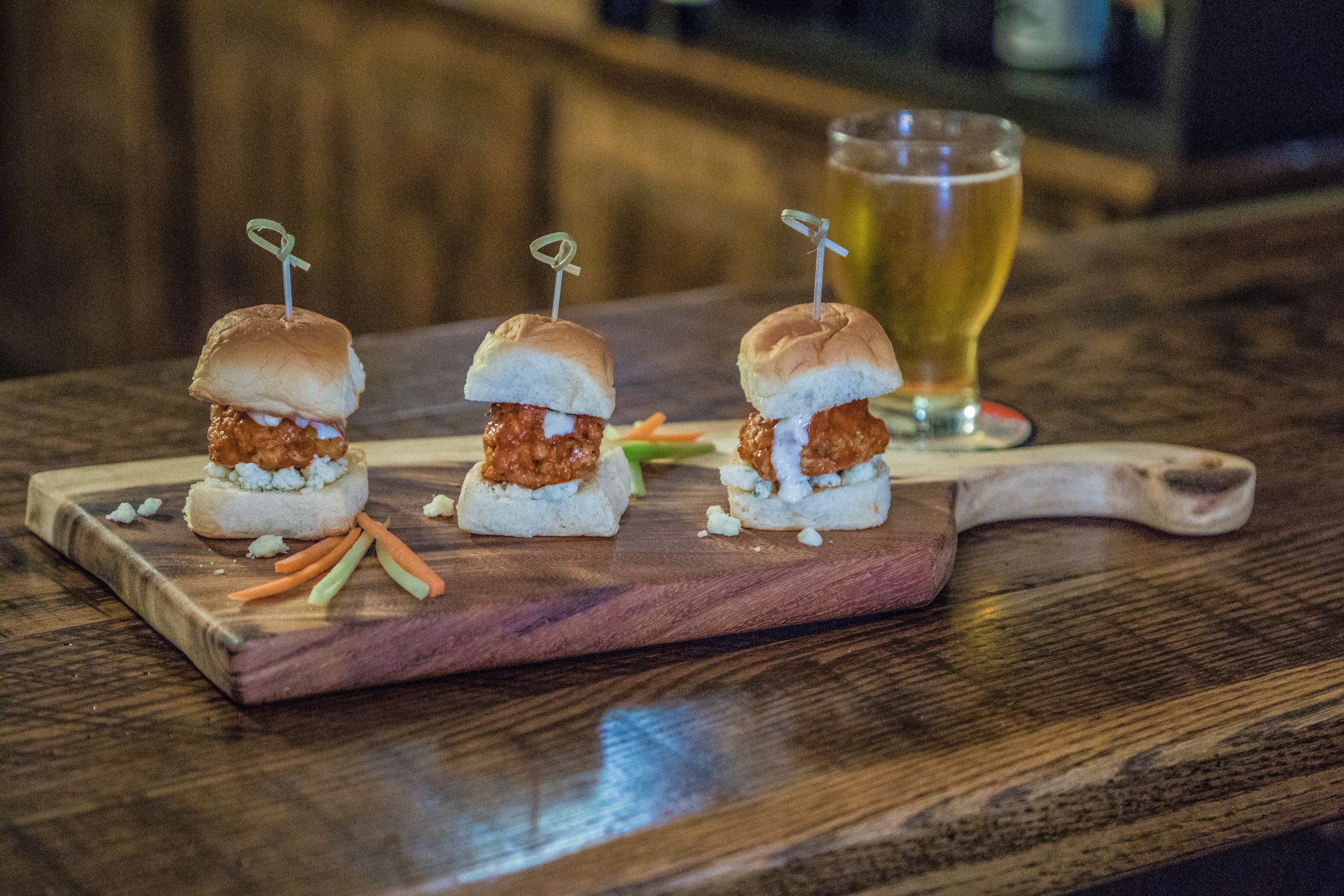Medium Live Edge Handled Board made from East Indian Walnut displayed with sliced foods