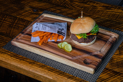 Medium Live Edge Square End Board with hanging hole and juice groove displayed on countertop with sliced food