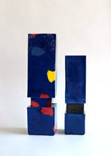 Two vertically stacked rectangular resin blocks in deep blue, the left one featuring scattered red and yellow patches, the right one solid blue with a small black connector.