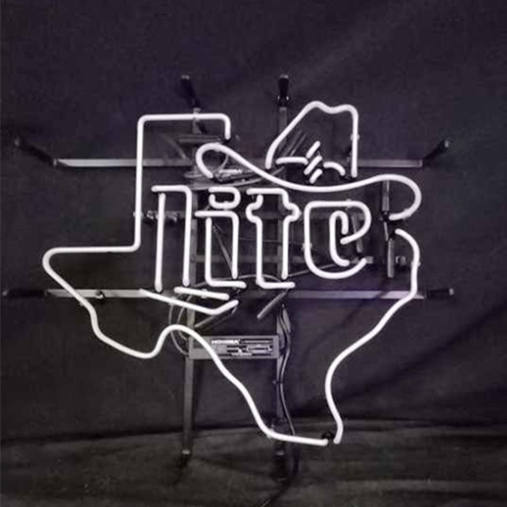 White neon sign shaped like the Texas state outline with a cowboy hat and the word 'lite' integrated inside, mounted on a dark background frame.