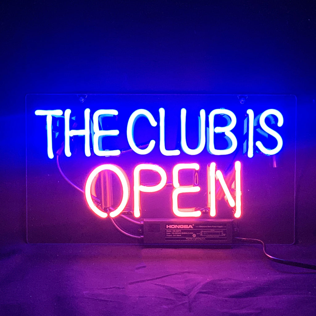 The Club is Open Neon Light Sign glowing in warm orange-red mounted on a wall