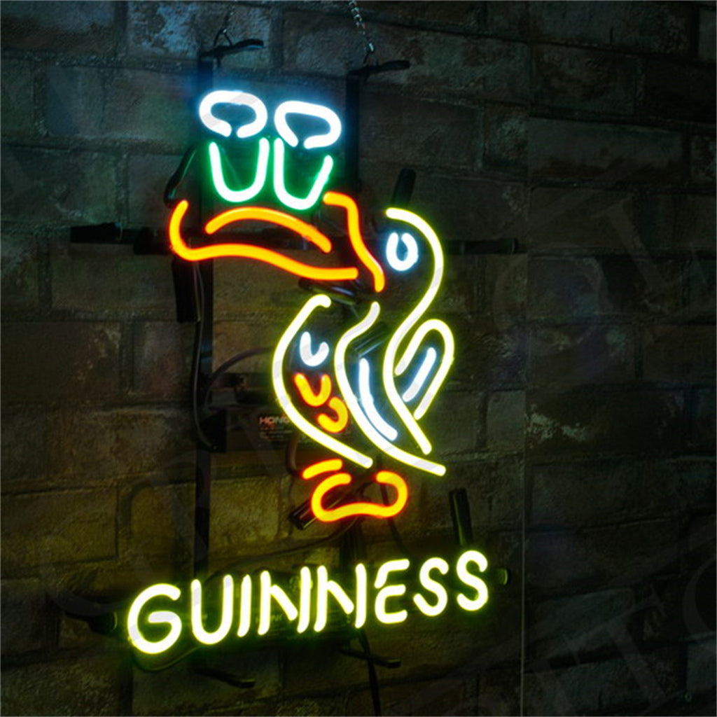 Neon sign of a toucan bird with brightly colored blue, green, yellow, orange, and white lights perched above yellow-green GUINNESS text on a stone wall background