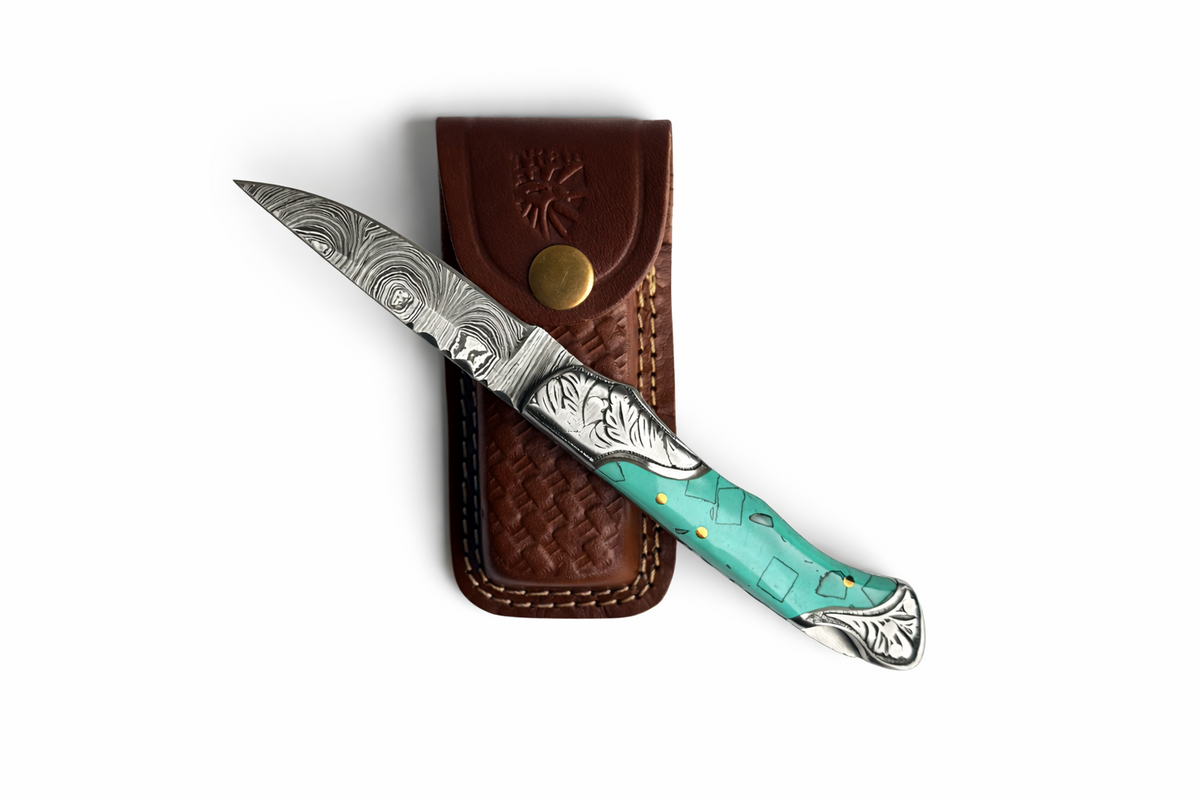Titan Turquoise Crest Damascus Folding Knife folded on top of its handcrafted leather sheath