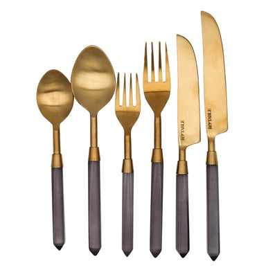 Four 6-piece sets of Ro'Table gold-toned stainless steel cutlery with bluey-grey sheer handles arranged on neutral surface