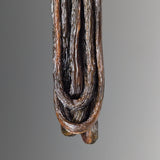 Close-up of a dark brown Ulvaxa Necklace by Versiliy made from elongated textured natural pods or seed-like elements hanging vertically against a neutral background.