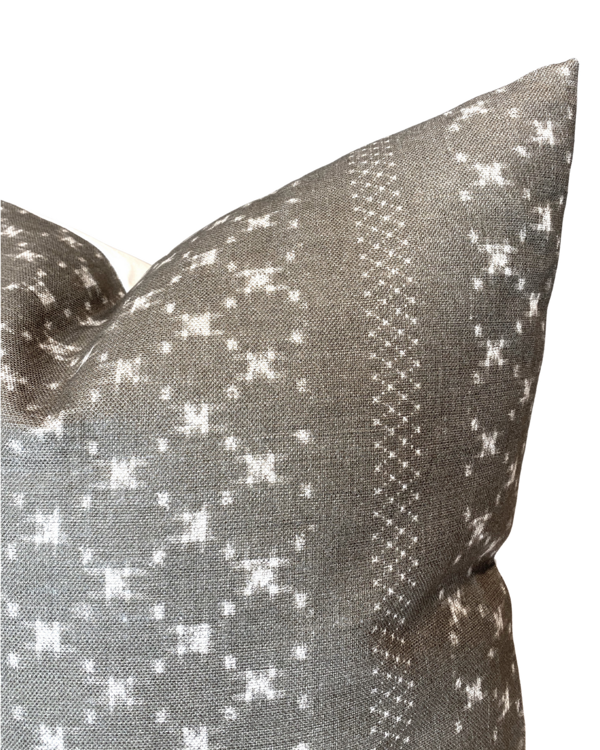 Close-up of a pillow cover in earth grey with white geometric and dotted patterns, featuring a textured woven fabric from McLaurin + Piercy Textiles.