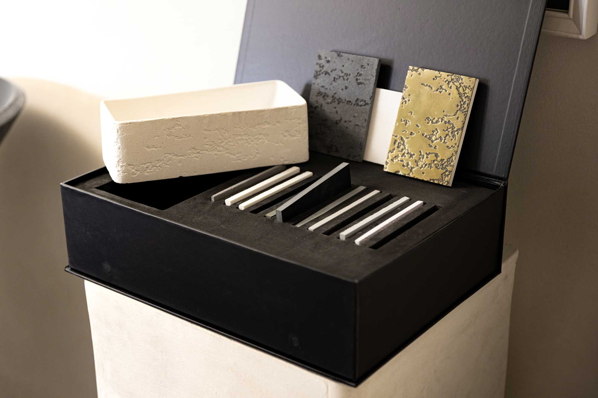 VAST Studio Bespoke Finish Samples box with miniature white textured concrete bathtub and ten finish samples arranged on a surface