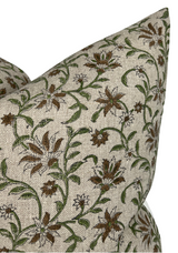 Close-up of two beige pillow covers with an intricate vine print featuring green stems and brown flowers on textured fabric.