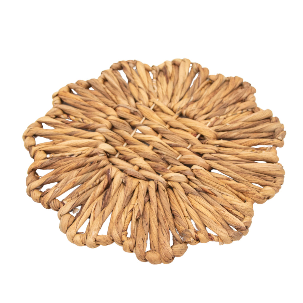 Set of four scalloped natural rattan chargers stacked on a woven surface